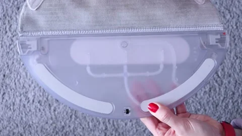 Female hands insert a rag in plastic nozzle for a robot vacuum cleaner. Stock Footage 221358241