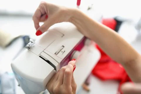 Female hands insert thread into sewing machine Stock Photos