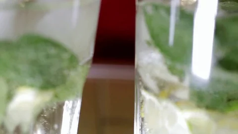 Female hands insert the tubes into glasses with a refreshing transparent drink Stock Footage 104518405
