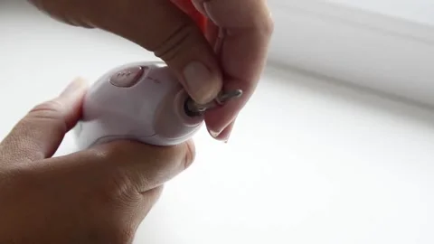Female hands inserting a manicure drill bit into an electric nail drill machine. 스톡 동영상 339006254