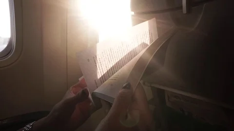 Female hands keep the book in the plane Stock Footage 77280625