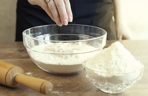 Female hands knead yeast dough in a glass bowl. Baking concept Stock Photos