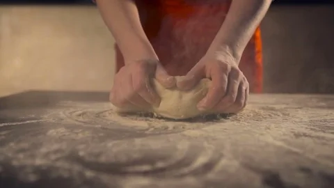 Female hands kneading dough in flour on table.Slow motion Stock Footage