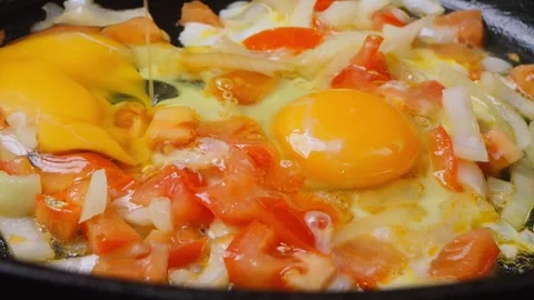 Female hands with a knife breaks eggs into a frying pan with vegetables. Me.. Stock Footage 264155477