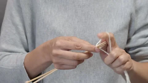 Female hands knits with wool threads and bamboo wooden needles on sofa at home Stock Footage 209601341