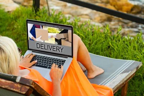 Female hands on laptop computer with parcel delivery application on screen at Stock Photos