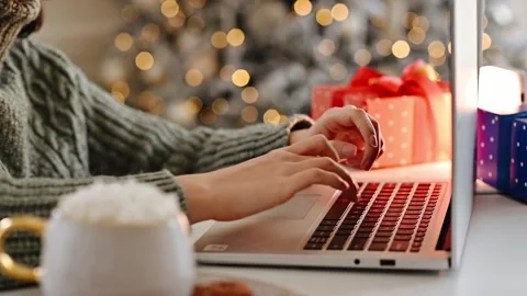 Female hands on laptop typing with blurred bokeh christmas lights 스톡 동영상 250187953