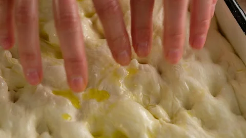 Female hands lay the dough in baking tray, prepare Italian bread - focaccia with Stock Footage 131801738