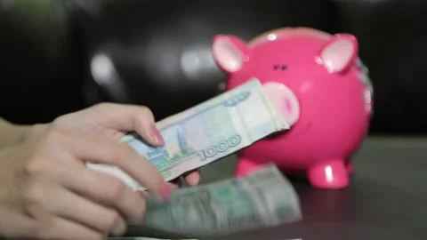 Female hands lay out banknotes, there is a piggy bank nearby Vídeos de archivo 158909623