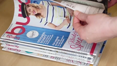 Female hands leafing through a stack of German fashion magazines of the Burda Video stock 169705457
