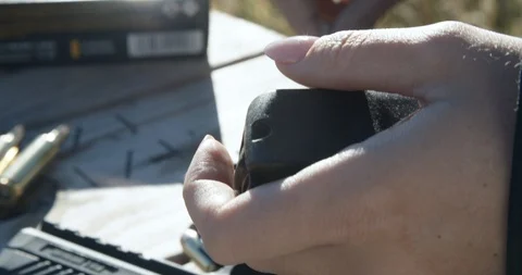 Female hands loading ammunition rounds into magazine Video stock 103238884