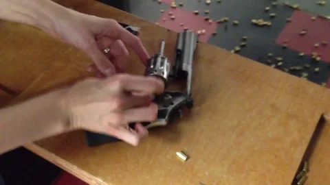 Female hands loading bullets into revolving chamber Stock Footage 74478287