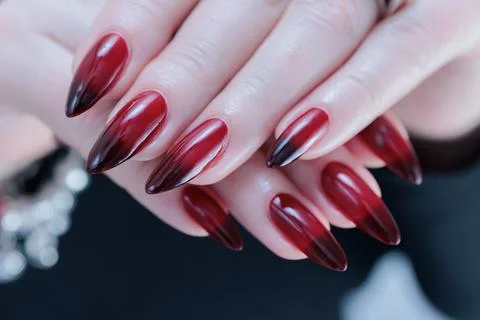 Female hands with long nails and black and red nail polish Stock Photos