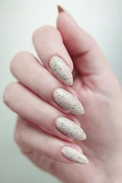 Female hands with long nails light white manicure and a bottle of nail polish 스톡 사진