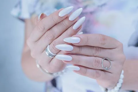Female hands with long nails light white manicure 库存照片