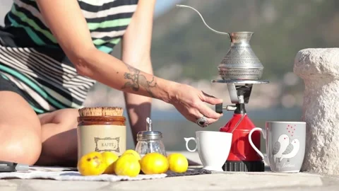 Female hands making coffee in cezve and turn on camp gas burner outdoors Stock Footage 165078980