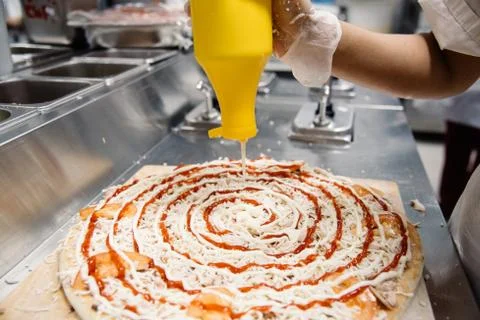 Female hands in making, decorating, preparing pizza. Close up Stock Photos