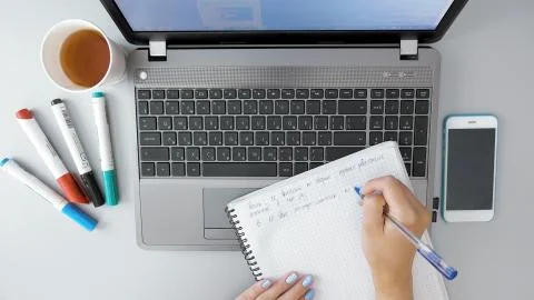 Female hands making notes in paper notebook by pen Stock Photos