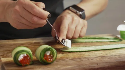 Female hands making snack roll of caviar cheese and cucumber Video stock 99636697