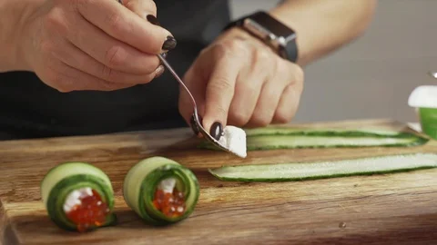 Female hands making snack roll of caviar cheese and cucumber Stock Footage 99641080