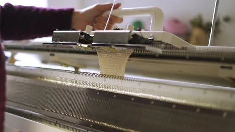 Female hands making weaving pattern on knitting machine in textile workshop Stock Footage 87380730