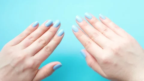 Female hands with manicure on blue background, top view. Stock Footage 238427009