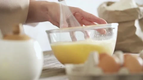 Female hands mix eggs. Close-up. Kitchen electric mixer knocks eggs in trans Stock Footage 156264169