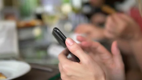 Female hands with a mobile smartphone using a smartphone gadget in a restaurant Stock Footage 114718058