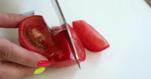 Female hands with multi-colored manicure cut tomatoes for salad Video stock 133826857