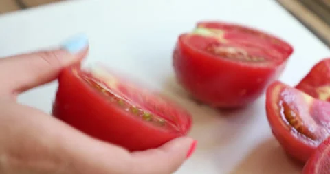 Female hands with multi-colored manicure cut and peel a tomatoes Stock Footage 133827423