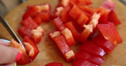 Female hands with multi-colored manicure chop bell pepper  to the salad Stock Footage 133830541
