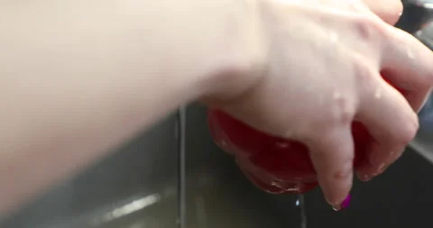 Female hands with multi-colored manicure wash, cut and peel red bell pepper Stock Footage 133835607