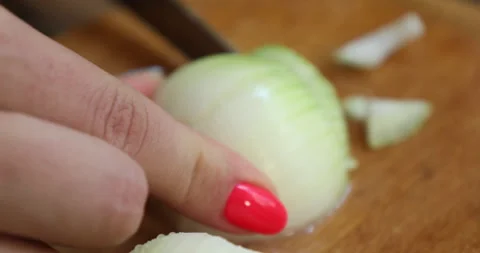 Female hands with multi-colored nails chop the onion into pieces Video stock 133828438