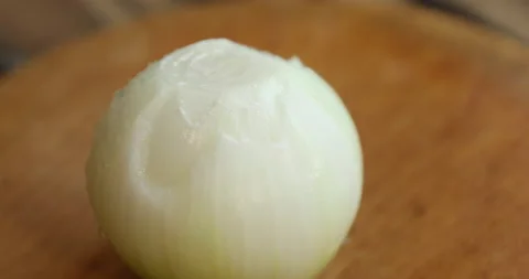 Female hands with multi-colored nails cut the onion in half Stock Footage 133829408