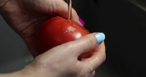 Female hands with multi-colored nails wash tomatoes Stock Footage 133834695