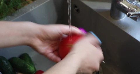 Female hands with multi-colored nails wash tomatoes Video stock 133835890