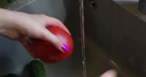 Female hands with multi-colored nails wash tomatoes Stock Footage 133835935