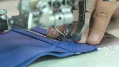 Female hands neat stitch zipper to leather piece on sewing machine. Concept Stock Footage