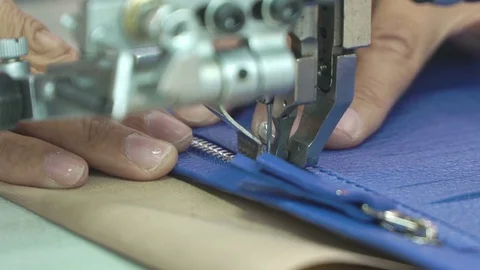 Female hands neat stitch zipper to leather piece on sewing machine. Concept Stock Footage