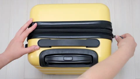 Female hands open the lock on yellow suitcase close-up top view. Stock Footage 252873328