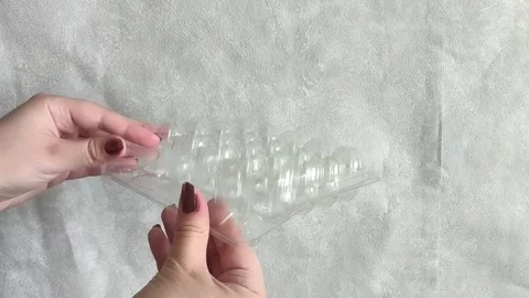 Female hands opening empty transparent plastic tray for quail eggs 库存影片 332409912
