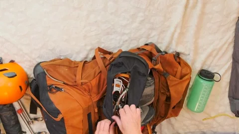 Female hands packing hiking backpack in top view timelapse, placing mountain Stock Footage 334945793