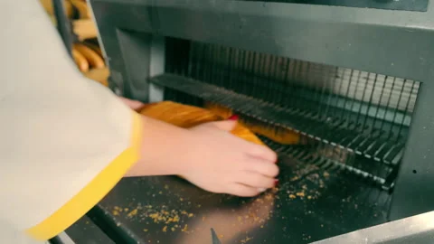 Female hands packing sliced bread after automatic slicing in indoor factory. The Stock Footage 256634446