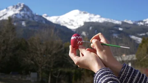 Female hands paint an Easter egg in the mountains Stock Footage 83550580