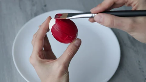 Female hands paint Easter egg in a modern minimalist style with red paint Video stock 180415071