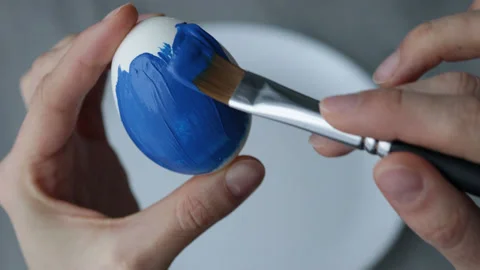 Female hands paint Easter egg in a modern minimalist style with blue paint Stock Footage 180417156