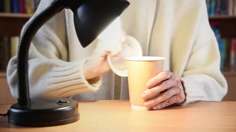 Female hands with paper coffee cup under lamp. Stock Footage 178411983