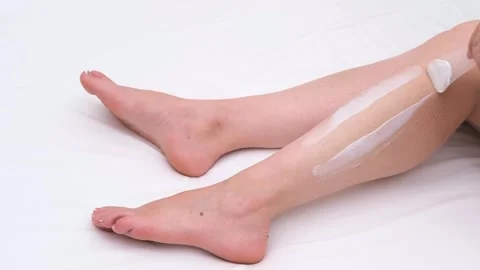 Female hands with pedicure doing depilation on legs Stock-Footage 310044862