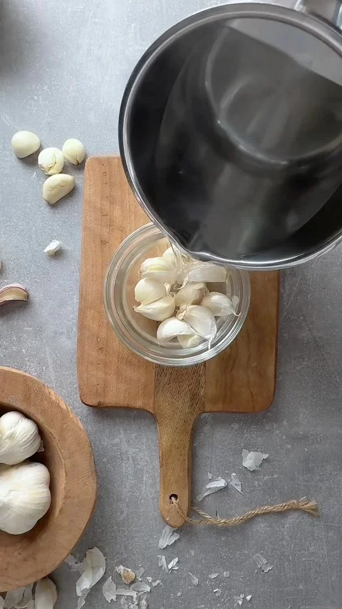 Female hands peel garlic using the hot water method. Stock Footage 300207499
