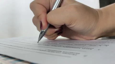 Female hands with pen signing documents, business papers on wooden table. Sign Stock Footage 314359385
